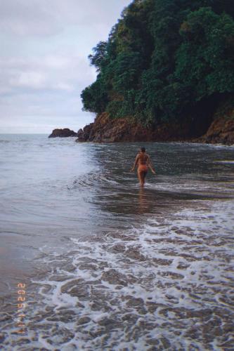 a man walking in the water on a beach at Posada Brisas del Cachcal in Panguí
