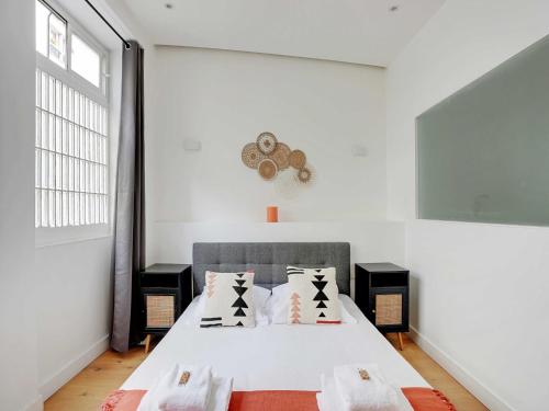 - une chambre blanche avec un lit et des oreillers dans l'établissement Apartment in Bastille with 1 room, à Paris
