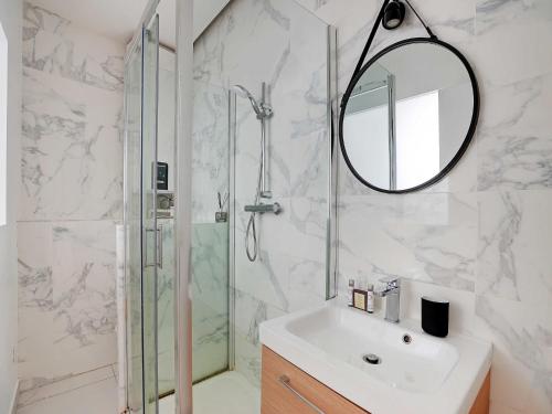 une salle de bain avec un lavabo et une douche avec un miroir dans l'établissement Apartment in Bastille with 1 room, à Paris