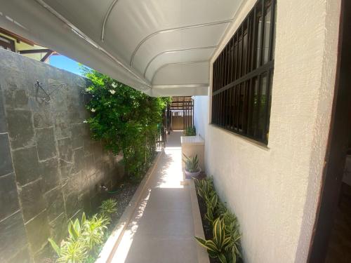 an empty hallway with plants on the side of a building at Casa poucos passos do mar em Buraco da Velha in Lauro de Freitas