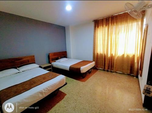 a hotel room with two beds and a window at Medellin Continental Hotel in Medellín