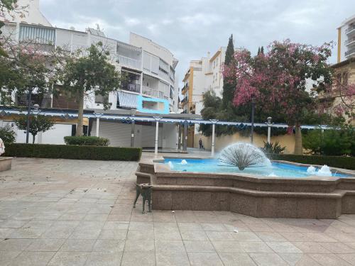 a fountain in a courtyard with a cat standing next to it at Apartamento en Paseo Larios de Torre del mar in Torre del Mar
