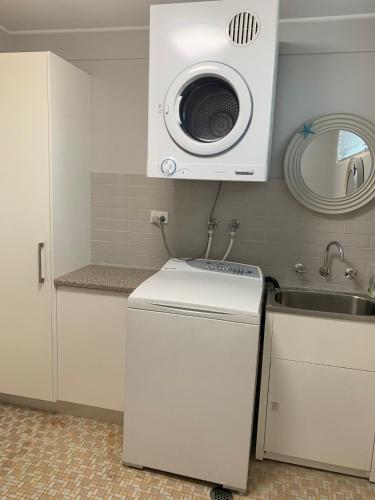 a microwave above a sink in a kitchen at Starfish Cottage in Cams Wharf