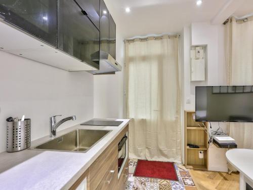 une cuisine avec un évier en acier inoxydable et une fenêtre dans l'établissement Cosy apartment - 1BR 4P - Sentier Grand Rex, à Paris