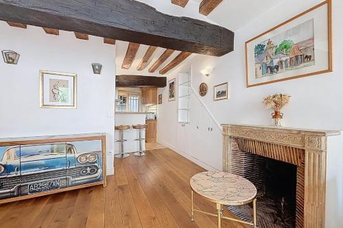 un salon avec une cheminée et une table dans l'établissement Charming Studio in the heart of Saint-Germain, à Paris
