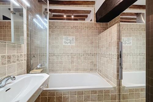 une salle de bain avec une baignoire et un lavabo dans l'établissement Charming Studio in the heart of Saint-Germain, à Paris