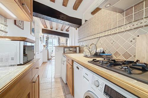 une cuisine avec un évier et une cuisinière four supérieur dans l'établissement Charming Studio in the heart of Saint-Germain, à Paris