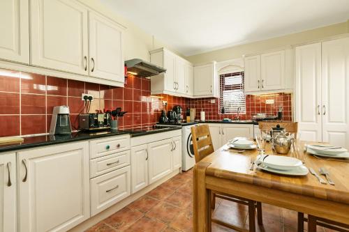 a kitchen with white cabinets and a wooden table at Union Place in Sligo