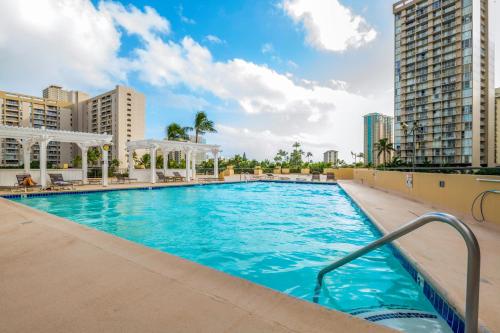 a swimming pool at a hotel with tall buildings at Hawaiian Monarch Penthouse 402 in Honolulu