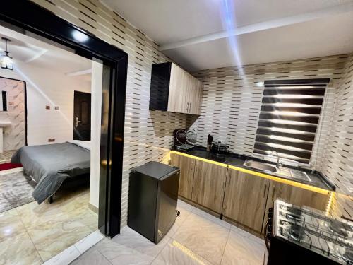 a kitchen with a sink and a bed in a room at Konar-Apts, Cozy Room with private kitchen, City view Balcony, 24hrs power, Security, Wifi, Gwarinpa Express by Dawaki Junction in Gwarinpa