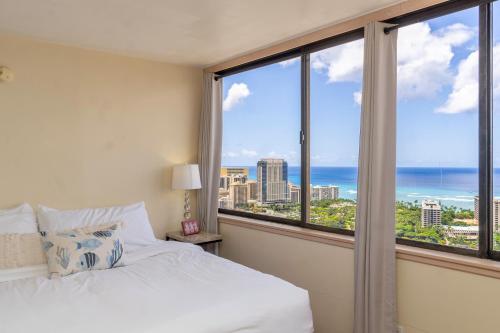 a bedroom with a bed and a view of the ocean at Hawaiian Monarch Penthouse 402 in Honolulu