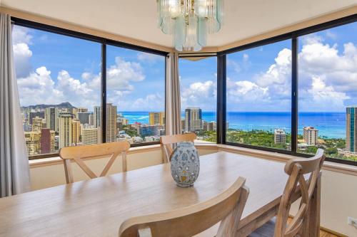 a dining room with a table and views of the ocean at Hawaiian Monarch Penthouse 402 in Honolulu