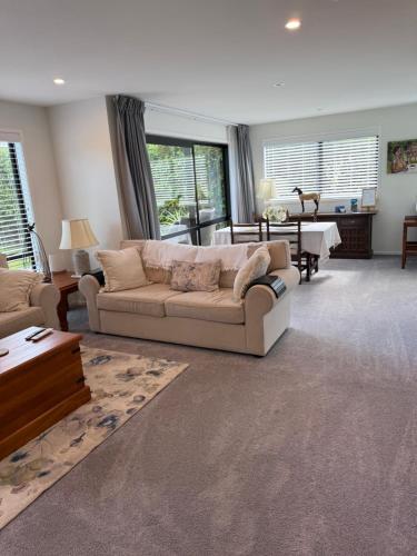 a living room with a couch and a table at The Gate House in Tauranga
