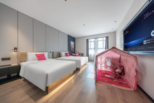 a hotel room with two beds and a tv at Atour Hotel Nanjing Drum Tower Square East Beijing Road in Nanjing