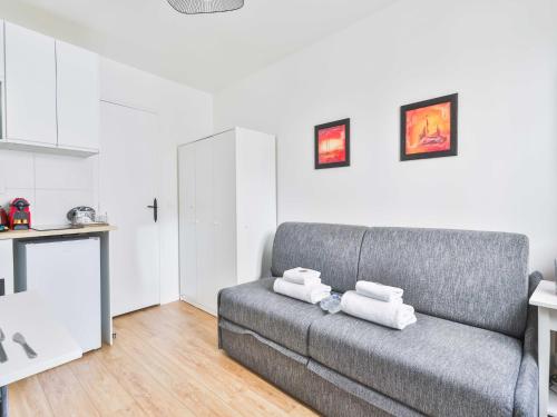 Il comprend un salon avec un canapé gris et une cuisine. dans l'établissement Cozy appartement -2P- Accor Arena Bercy, à Paris