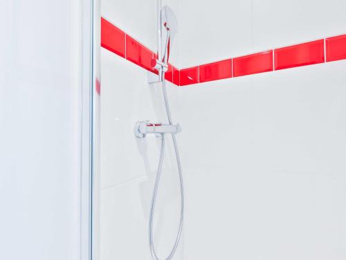 une douche avec un tuyau suspendu à un portant rouge dans l'établissement Cozy appartement -2P- Accor Arena Bercy, à Paris