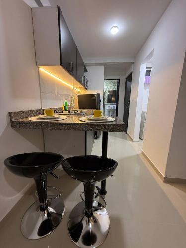 a kitchen with two bar stools and a counter in a room at Granada Luxury Loft in Cali