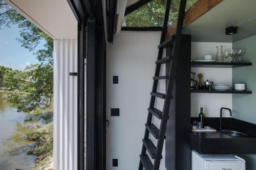 a kitchen with a spiral staircase next to a window at Refúgio com Lago Privativo no Vale dos Vinhedos in Garibaldi