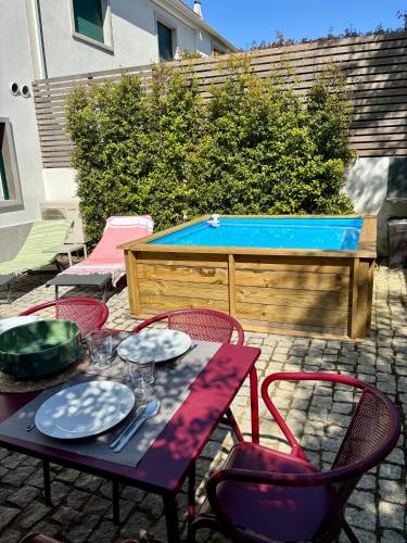 a table and chairs in front of a swimming pool at Augusto - a family house with pool in the heart of Lisbon in Lisbon