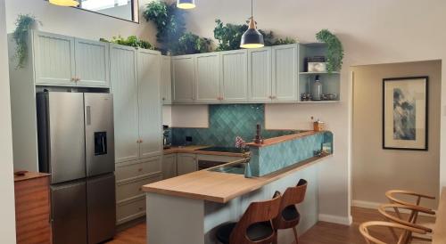 a kitchen with white cabinets and a stainless steel refrigerator at Island House in Albany