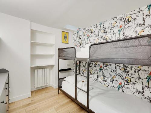 une chambre avec deux lits superposés et un papier peint dans l'établissement Authentic Loft - 2BR 8P - Oberkampf, à Paris
