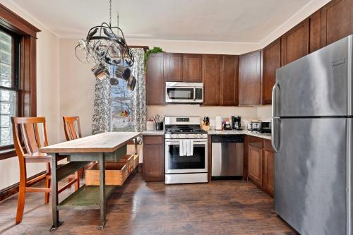 a kitchen with wooden cabinets and a stainless steel refrigerator at Vintage 3 Bed Condo in Chicagolands Trendy Berwyn condo in Berwyn