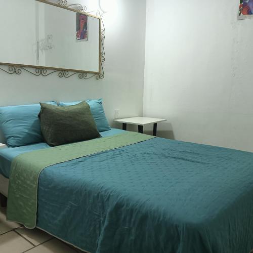 a bedroom with a blue bed with a mirror on the wall at Alexandross in Puerto Vallarta