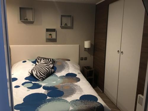 a bedroom with a bed with a zebra pillow on it at Mobilhome familial 6 à 7 p 3 chambres 42 m2 Saint Brévin Les Pierres Couchées in Saint-Brevin-les-Pins