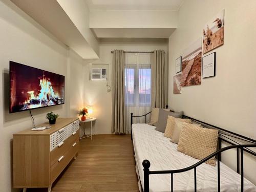 a bedroom with a bed and a tv on the wall at 8F Cozy 1-Bedroom Unit The Loop Towers in Cagayan de Oro