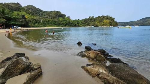 a group of people in the water at a beach at Recanto Machado in Paraty
