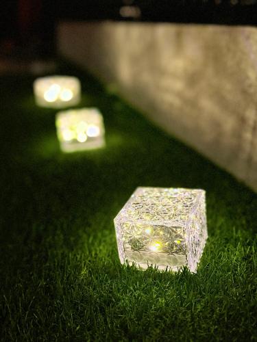 a small crystal block sitting in the grass with lights at いろどり荘 ドッグラン併設 露天風呂付き in Inokuchi