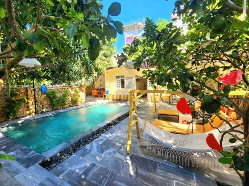 a swimming pool with two chairs and a resort at Garden House Nha Trang in Nha Trang