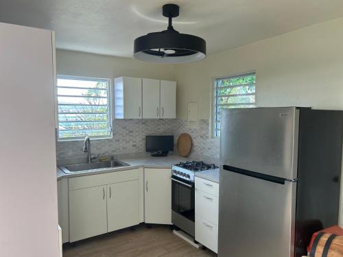 a kitchen with white cabinets and a stainless steel refrigerator at Come, Enjoy & Relax DaiquiriVille on Culebra Island Puerto Rico in Culebra