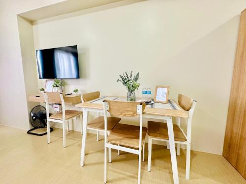 a dining room with a white table and chairs at 2F Cozy Studio Unit at Aspira Avida Tower 2 in Cagayan de Oro