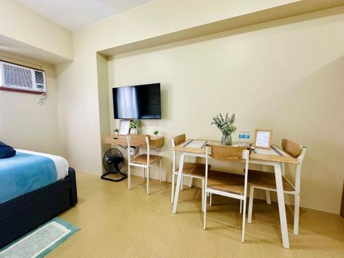 a bedroom with a bed and a table and a desk at 2F Cozy Studio Unit at Aspira Avida Tower 2 in Cagayan de Oro