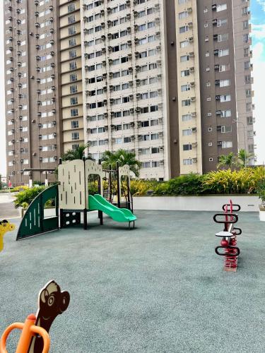 a playground with two play equipment in front of a large building at 2F Cozy Studio Unit at Aspira Avida Tower 2 in Cagayan de Oro