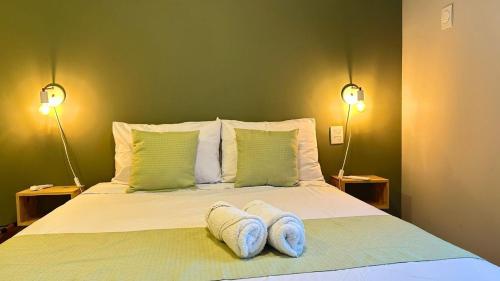 a bed with two white towels on it with two lamps at Apto 2 qtos na quadra da praia Itaparica in Itaparica