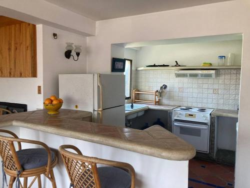 eine Küche mit einem Kühlschrank und einer Theke mit Stühlen in der Unterkunft Valle Sol in El Valle del Espíritu Santo