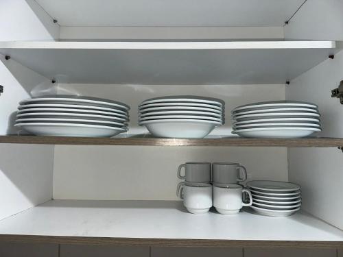 a shelf with plates and other dishes on it at Apto 2 qtos na quadra da praia Itaparica in Itaparica