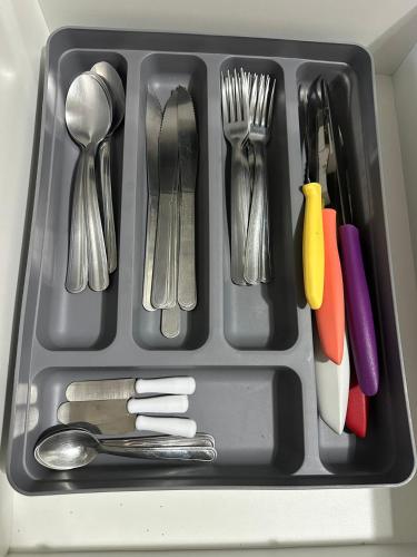 a tray filled with utensils in a sink at Apto 2 qtos na quadra da praia Itaparica in Itaparica