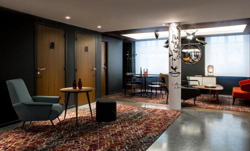 a lobby with chairs and tables and a pole at Le Général Hôtel in Paris