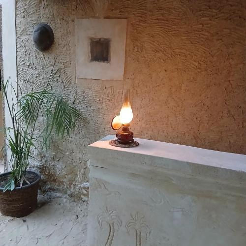 a lit candle sitting on top of a wall at Tanirt ecolodge in Siwa