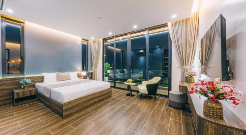 een hotelkamer met een bed en een bureau met bloemen bij Lucy Villa Sầm Sơn in Sầm Sơn