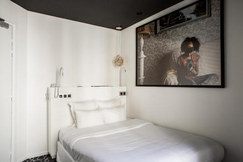 a bedroom with a bed with a picture on the wall at Le Général Hôtel in Paris