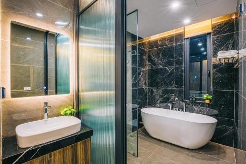 een badkamer met een bad en een wastafel bij Lucy Villa Sầm Sơn in Sầm Sơn