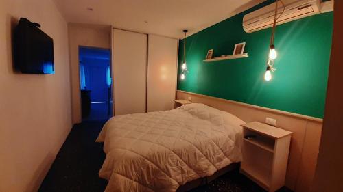 a bedroom with a bed and a green wall at El rinconcito de Lamadrid in Concordia