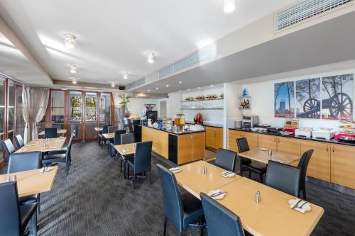 a restaurant with wooden tables and chairs and a counter at City Apartment 2xfree parking - Pool - Gym Wi-Fi in Perth