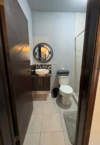 a bathroom with a toilet and a sink and a mirror at Estancias Nava #4 in San Antonio