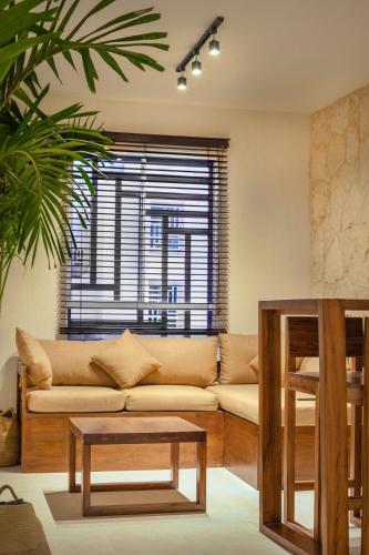 a living room with a couch and a table at Departamento en Aldea Tulum in Tulum