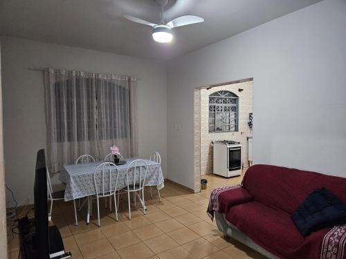 a living room with a table and a couch at Casa Familiar espaçosa e confortável em Aparecida, com 3 quartos in Aparecida